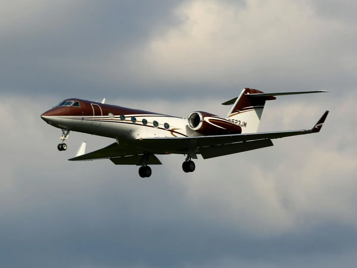 A business jet with burgundy trim in flight