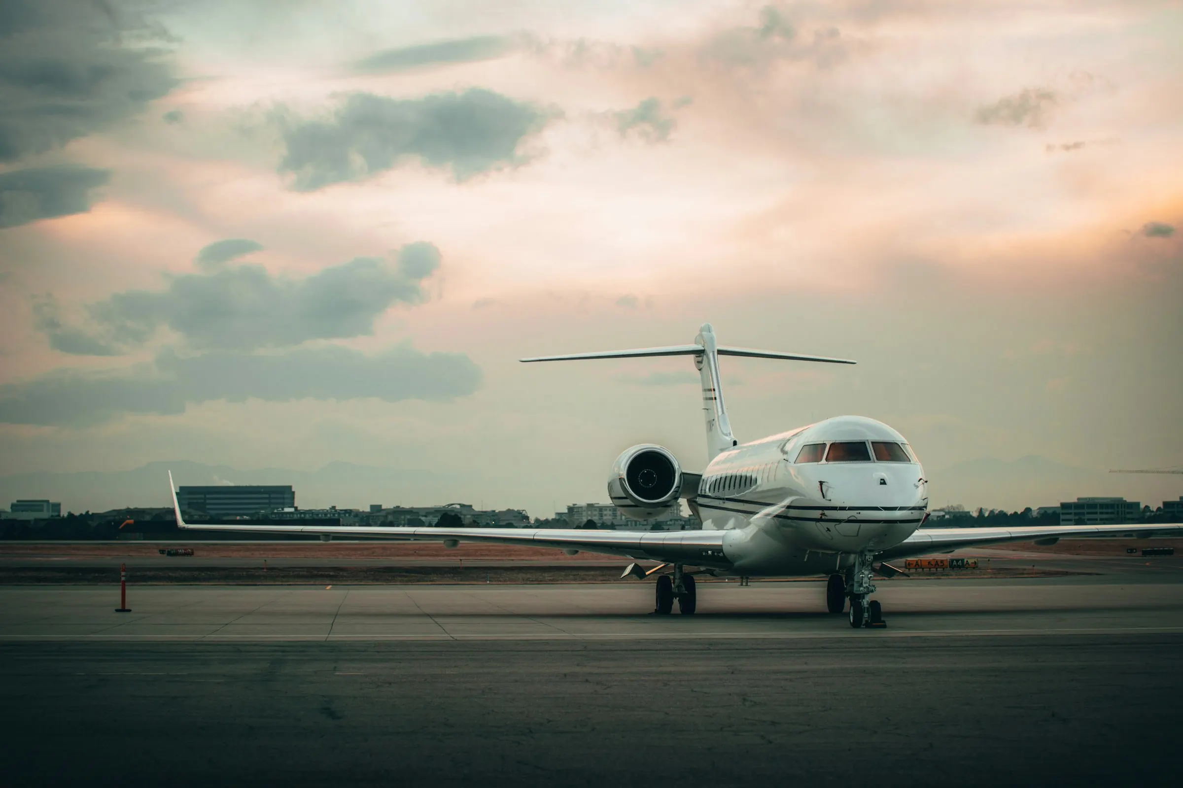 A private jet on the ramp at dusk under a wide evening sky